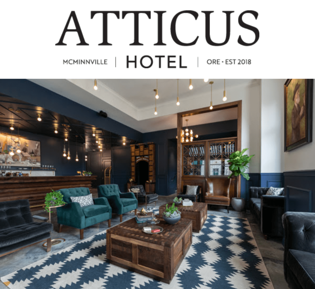 Image of the lobby of Atticus Hotel, which features dark wood furniture, dark blue painted walls, and a blue and white tiled carpet.